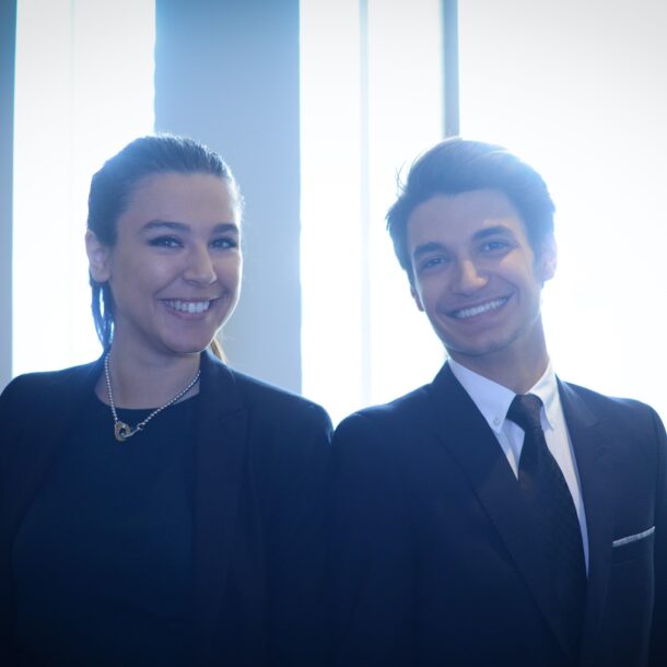 une jeune femme et un jeune homme en tenue pro sourient de tout leur coeur