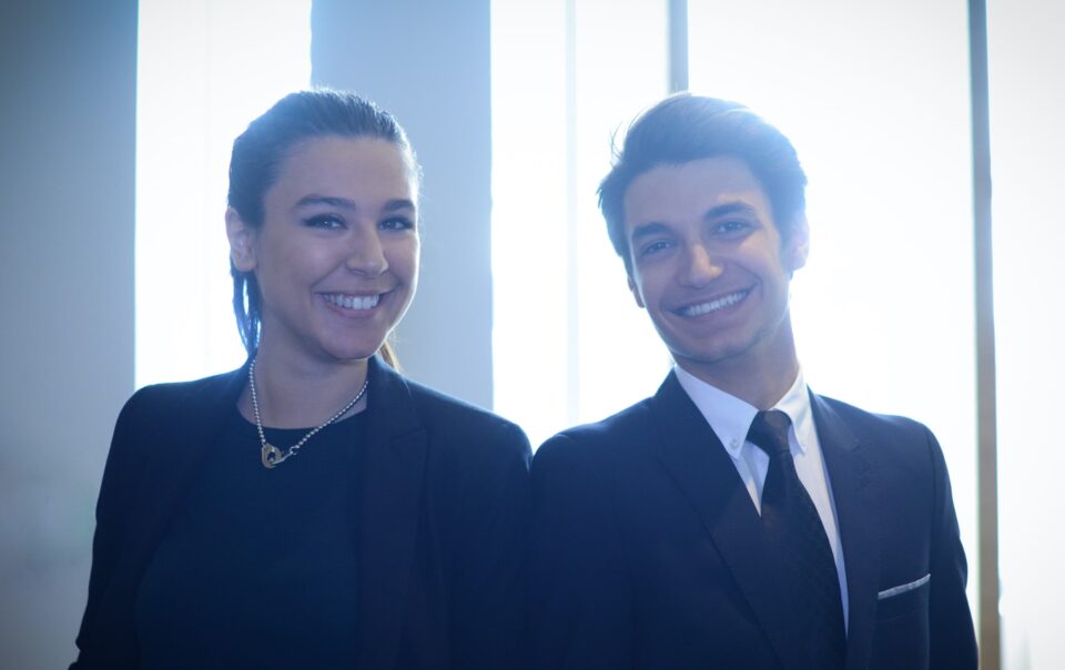 une jeune femme et un jeune homme en tenue pro sourient de tout leur coeur